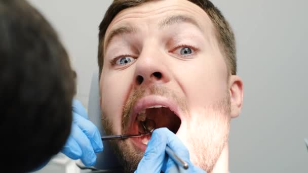 Крупним планом переляканого молодого пацієнта в стоматологічному кріслі під час лікування зубів. Стоматологічні інструменти
 - Кадри, відео
