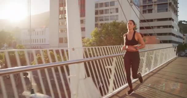 Fitness, runner and city bridge with woman running in sports exercise, healthy training or wellness workout outdoor in summer sun. Motivation, vision or goals for speed, body care and cardio strength. - Filmmaterial, Video