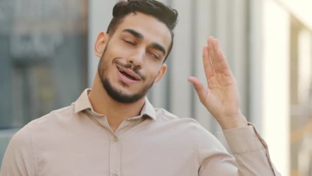 Закрыть эмоционально разочарованный мрачный мужской портрет на открытом воздухе в городе испаноязычный арабский бородатый индийский бизнесмен разочарованный показывая знак бла-бла-бла с жестом рукой пустые обещания - Кадры, видео
