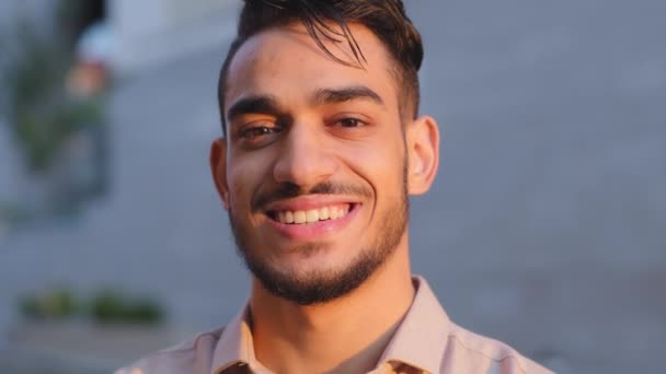 Close up head shot portrait in city outdoors Hispanic Arabian Latin Indian bearded businessman happy guy satisfied cheerful carefree man CEO boss leader smiling toothy looking at camera face in city - Materiaali, video