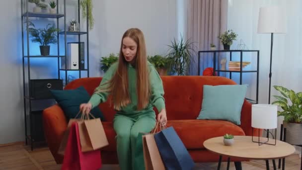 Portrait of caucasian teen girl happy shopaholic consumer came back home after shopping sale with bags. Young child kid satisfied received parcels from online order at home apartment living room - Materiał filmowy, wideo