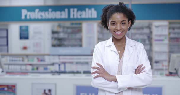 Portrait of a woman pharmacist with arms crossed and a smile in a pharmacy. Woman Healthcare doctor in a medical store or dispensary with boxes of pills or tablets on a shelf working with medication. - Imágenes, Vídeo