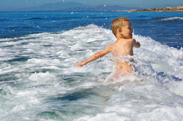 kind spelen in de zee - Foto, afbeelding