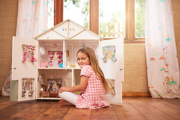 My days are never short of fun. Portrait of a little girl playing with her dollhouse at home - Foto, imagen