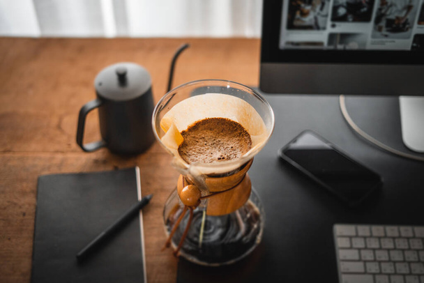 Coffee chemex наливают над кофеваркой и капают в домашний офисный стол - Фото, изображение