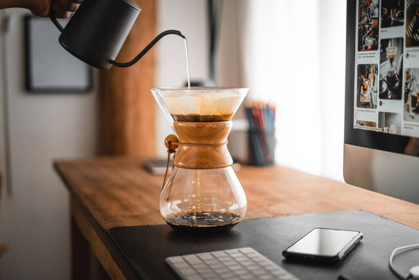 Coffee chemex наливают над кофеваркой и капают в домашний офисный стол - Фото, изображение