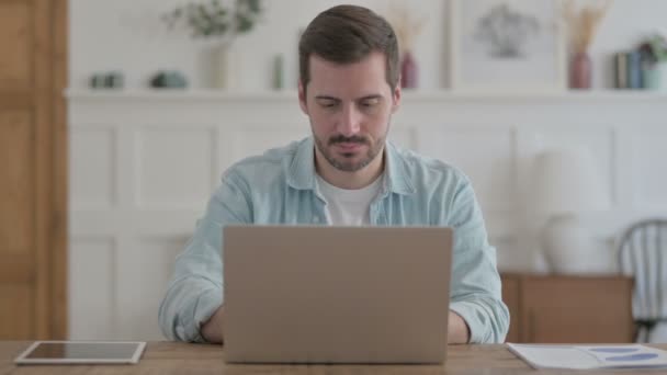 Casual Man Looking at Camera while using Laptop - Imágenes, Vídeo