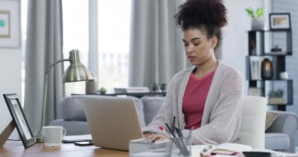 Внештатная чернокожая деловая женщина работает дистанционно на ноутбуке в домашнем офисе, печатает электронную почту и проводит исследования в Интернете. African American women browsing online, planning startup or marketing strategy. - Кадры, видео