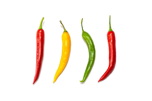 Shot of four hot peppers, red, green  and yellow,  lined up, isolated - Zdjęcie, obraz