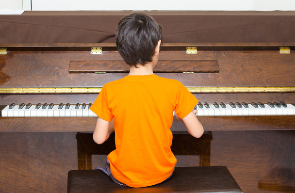 kleine jongen speelde piano - Foto, afbeelding