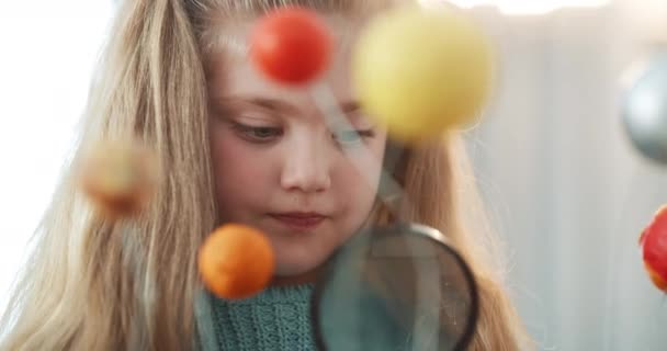 Education, science and student learning with a fun project of the solar system, home schooling with little girl. Learner inspect a globe model with a magnifying glass, being curious with creativity. - Felvétel, videó