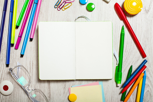 Abra el bloc de notas con páginas en blanco en la mesa con herramientas de oficina
 - Foto, imagen