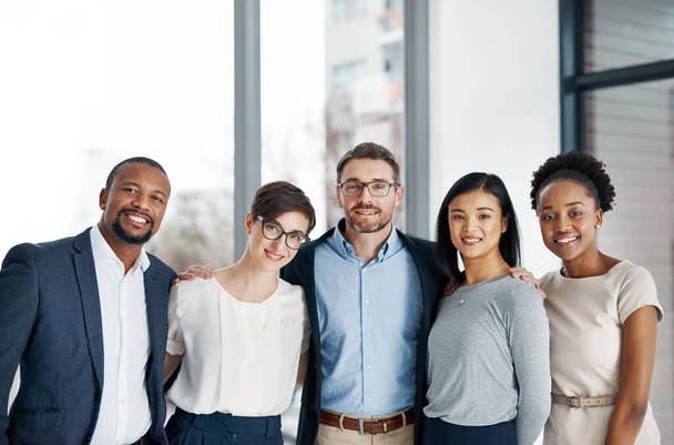 Working together cooperatively leads to increased and improved successes. Portrait of a diverse team of professionals standing together in an office - Fotoğraf, Görsel