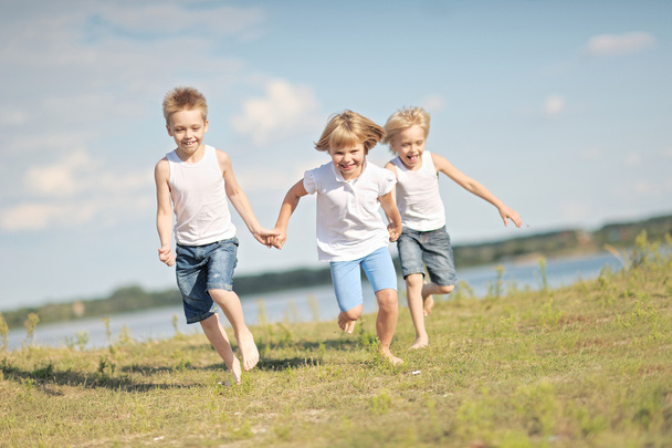 three children playing on meadow in summer - Φωτογραφία, εικόνα