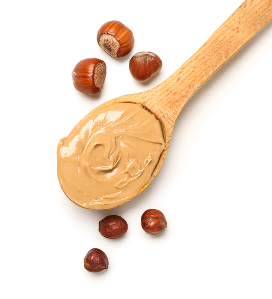 Wooden spoon with tasty hazelnut butter on white background, closeup - Foto, Imagem