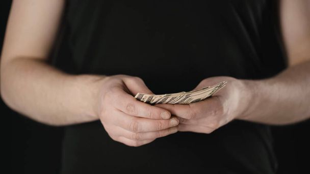 vista recortada del hombre contando billetes de dólar aislados en negro
 - Foto, imagen