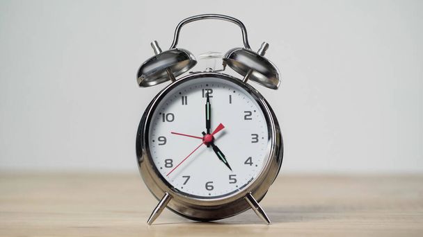 metallic and vintage alarm clock on wooden table isolated on grey  - Φωτογραφία, εικόνα