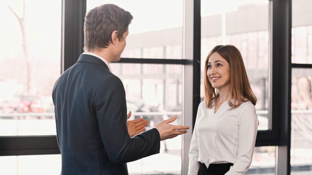 businessman pointing with hands at happy woman during job interview - Photo, Image