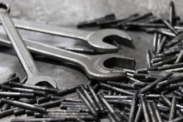 Wrench and screws. Industrial background. - Foto, imagen