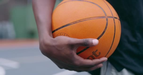 Basketball, sport and game with man holding ball in basketball court in social, exercise or competition club. Community, practice and professional athlete or basketball player at outdoor training. - Filmati, video