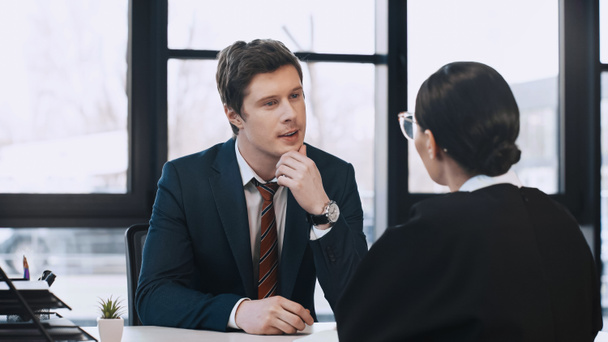 attentive businessman listening to brunette woman during job interview - Valokuva, kuva