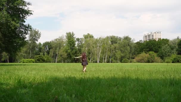 Girl run in field on green grass. Happy child plays and dream. Girl in flower garden.Happy child run towards dream on green grass. Girl playing on flower field in garden.Children fun and joy in summer - Imágenes, Vídeo