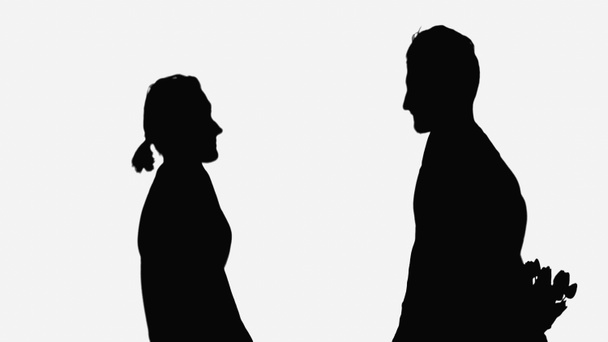 black silhouette of man holding bouquet behind back near woman isolated on white - Foto, Imagem