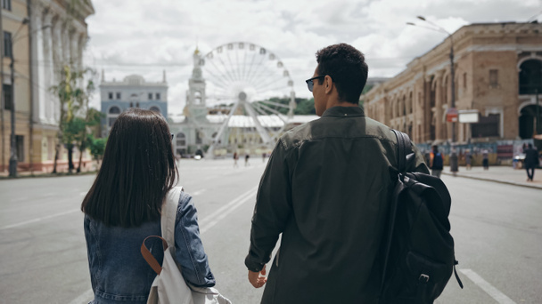 Multiethnic travelers with backpacks walking on european street  - Foto, imagen