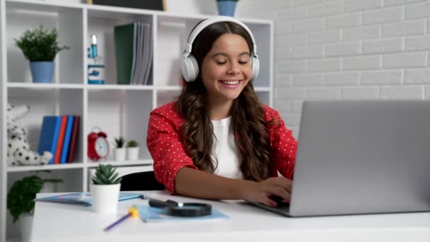 happy kid typing on laptop at online school lesson in earphones, modern life. - 映像、動画