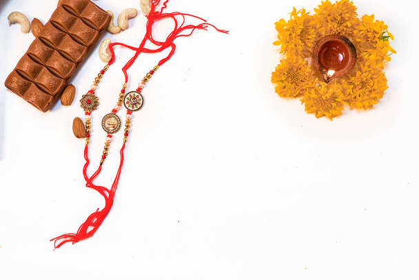 Conceptual rakhi background with chocolate dry fruits rice and flowers for rakshabandhan - Φωτογραφία, εικόνα
