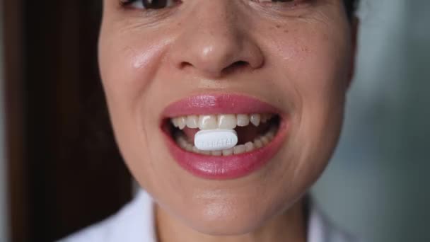 Selective focus on a white pill with vitamins, minerals and dietary supplement in the mouth of blurry happy pregnant woman, smiling beautiful toothy smile. Pregnancy care concept. Prenatal health - Metraje, vídeo