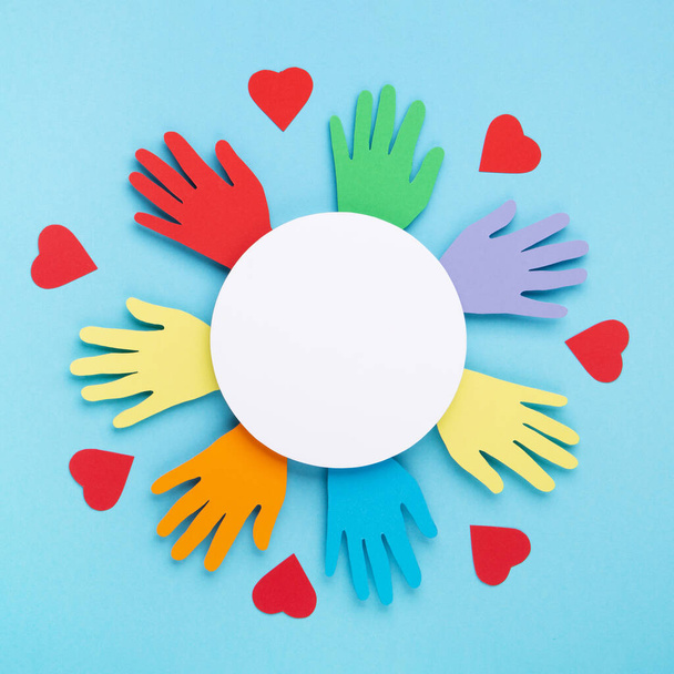 International Day of Charity, 5 September. Tolerance, kindness, cooperative, friendship, charity, humanitarian aid day concept. Colorful hands on blue background, copy space, top view. - Photo, Image
