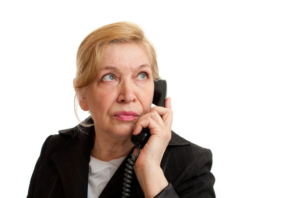 Senior Woman talking on the phone in black suite on white backgr - Фото, изображение
