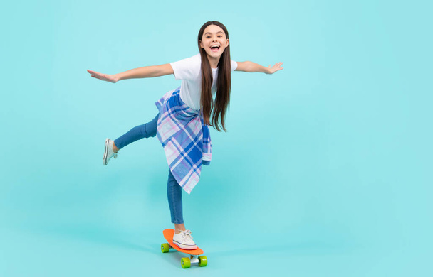 Teen hipster girl skater with skateboard on isolated background. Summer kids trend, urban teenage style. Jump and run. Happy teenager, positive and smiling emotions of teen girl - 写真・画像