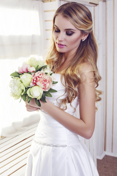 portrait of beautiful bride in elegant dress with wedding bouquet - Фото, изображение