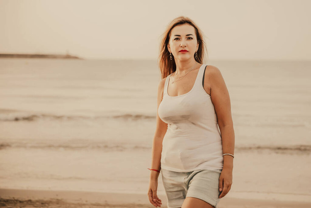 Portrait of a woman on the beach, ocean, unity with nature, healthy lifestyle - Foto, afbeelding