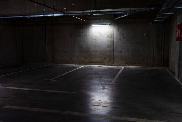 Pusty parking z przyciemnionym światłem, garaż podziemny. - Zdjęcie, obraz