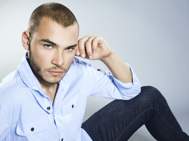 Handsome young man in blue shirt and jeans - 写真・画像