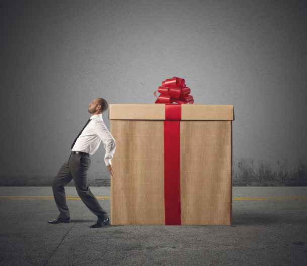 Businessman pushes heavy great gift - Photo, Image