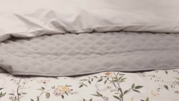 Постельное белье в винтажном деревенском стиле с цветочным узором на деревянной кровати в спальне, детали интерьера - Кадры, видео