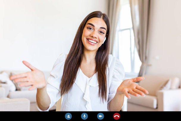 Attractive young woman smiling and looking at camera while having video call. Online teaching. Young woman wearing headphone - Foto, Imagen