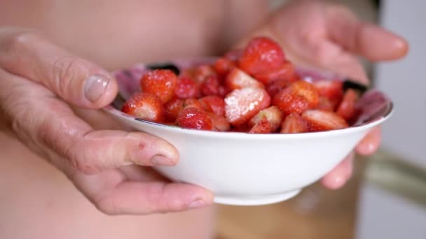 Hands Farmer Holding Full Glass Bowl Red a Strawberry in Sunlight. Blurred background. Berries harvest. Ripe berries are shining on daylight, sunshine. Healthy food, organic seasonal food. Vitamins. - Filmmaterial, Video