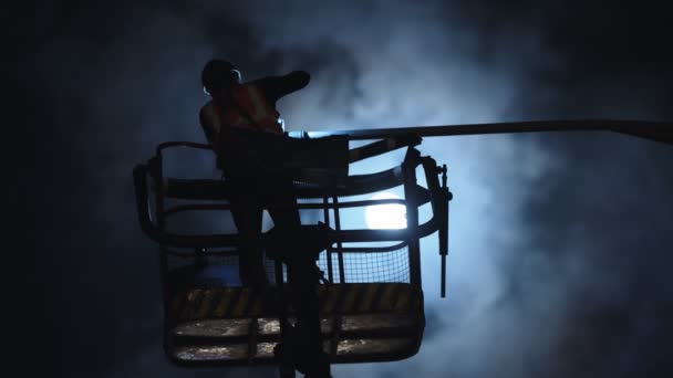 silhouette of a electric engineer working on a street lamp - Video