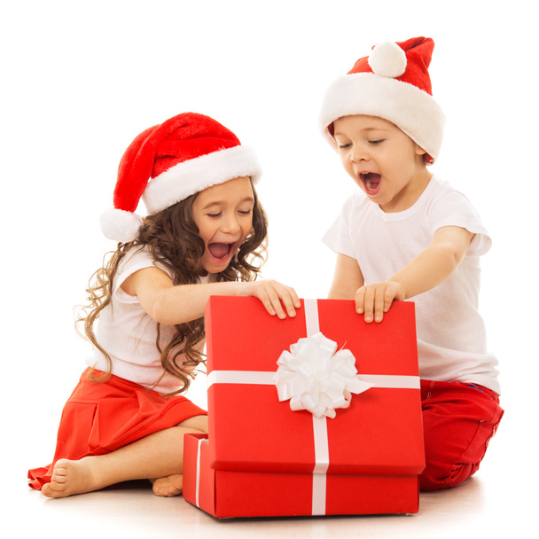 Boldog gyerekek a Santa kalap, nyitva egy ajándék doboz - Fotó, kép
