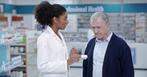 Healthcare, medical and pharmacist helping customer in pharmacy shop to find treatment or medicine for sick senior client. African doctor worker explaining medication instructions to an elderly man. - Video