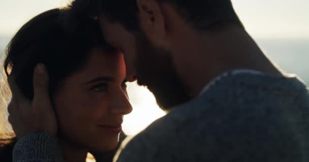 Couple, love and beach sunset with forehead touching on a summer holiday, ocean vacation and sea honeymoon with lens flare. Smile, happy and bonding man and woman in hug on relax nature date together. - Materiał filmowy, wideo