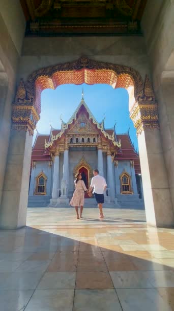 Wat Benchamabophit temple in Bangkok Thailand, The Marble temple in Bangkok Thailand, couple men and women visiting the Marble temple in Bangkok - Felvétel, videó