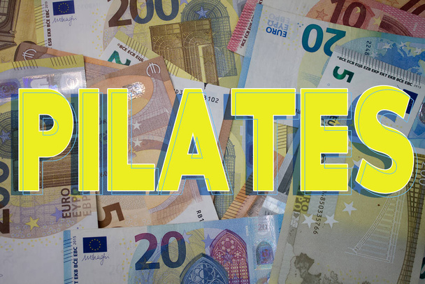 Pilates word with money. Paper currency background with different banknotes. - Foto, Imagen