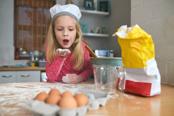 Shes a happy little baker. a little girl baking in the kitchen - Fotoğraf, Görsel
