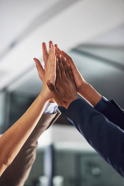 Inspired to be the best. Closeup shot of a group of colleagues giving each other a high five in an office - Photo, Image